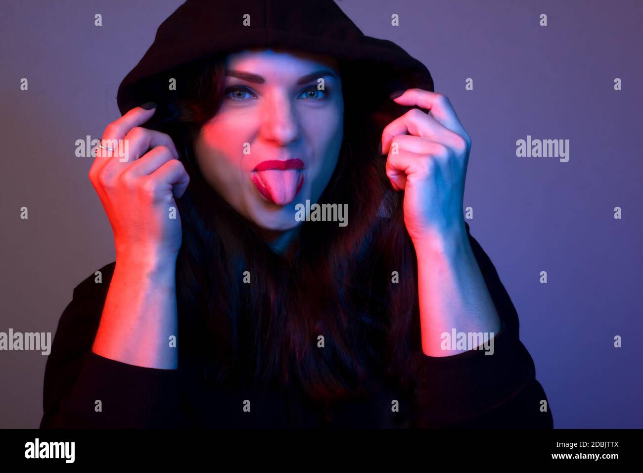 Ritratto di una giovane donna nello Studio. Volando intorno, mostrando la sua lingua Foto Stock