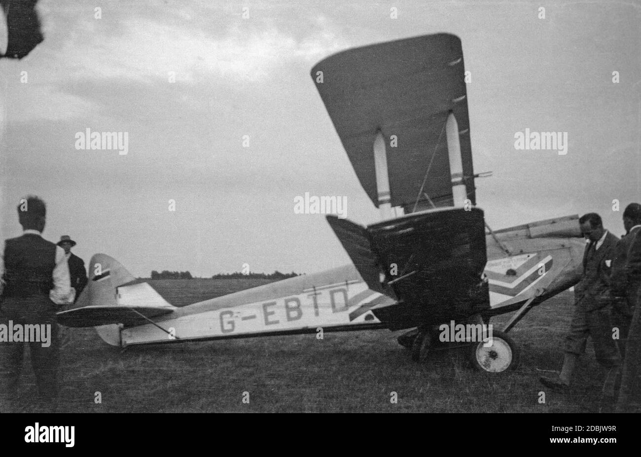 Un velivolo De Havilland DH 60X Moth, registrazione G-EBTD, in un campo aereo in Inghilterra nel 1937 dopo un guasto al carro. Alcuni uomini che guardano intorno al velivolo. Foto Stock