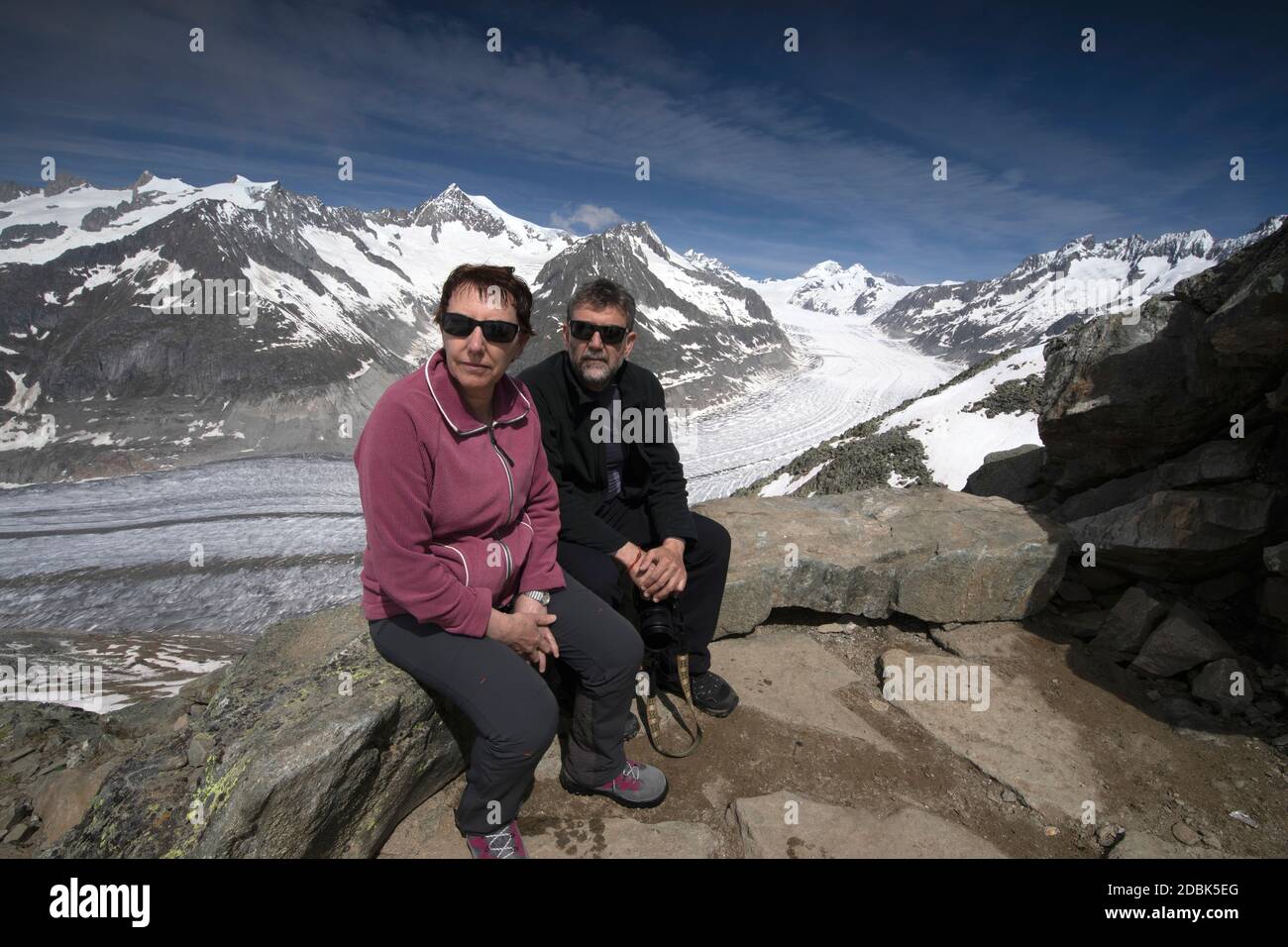Coppia seduta di fronte al ghiacciaio Aletsch, Svizzera Foto Stock