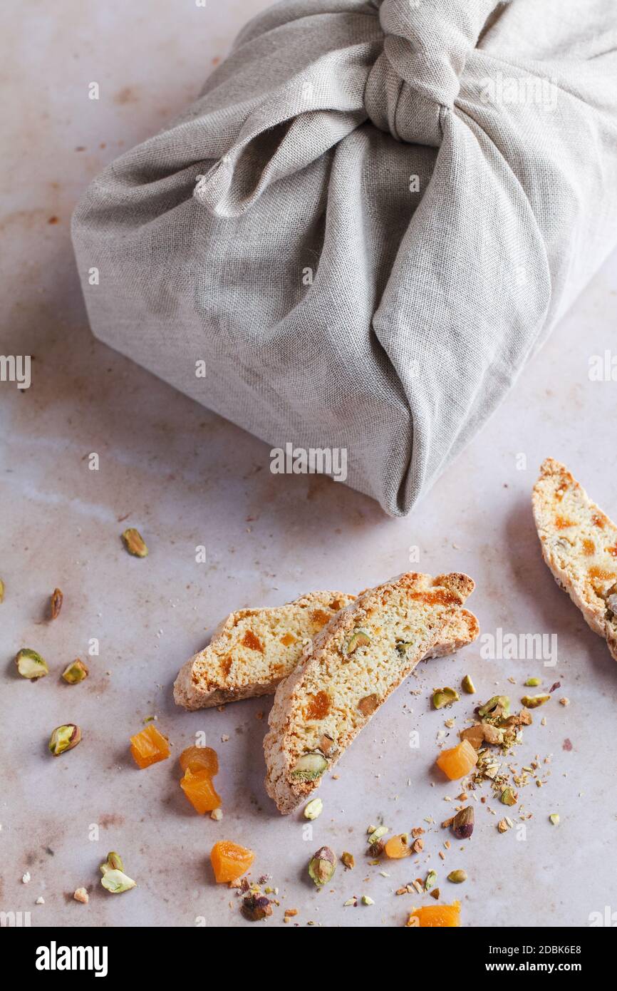 Regalo gastronomico di bicotti di albicocca e pistacchio avvolti in tessuto Utilizzando il metodo furoshiki (confezione regalo giapponese) Foto Stock