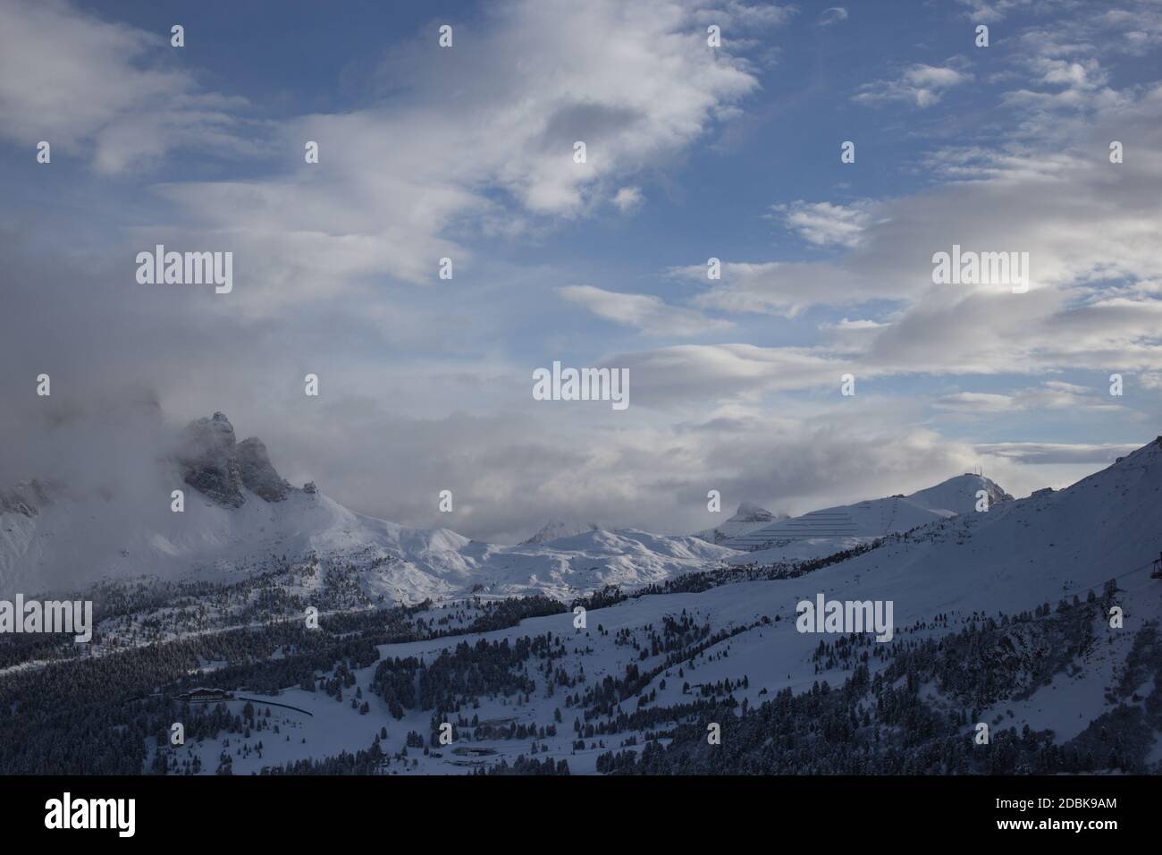 Vista del gruppo del Sella e della valle tra le nuvole, in inverno, Val Gardena, Dolomiti, Italia Foto Stock