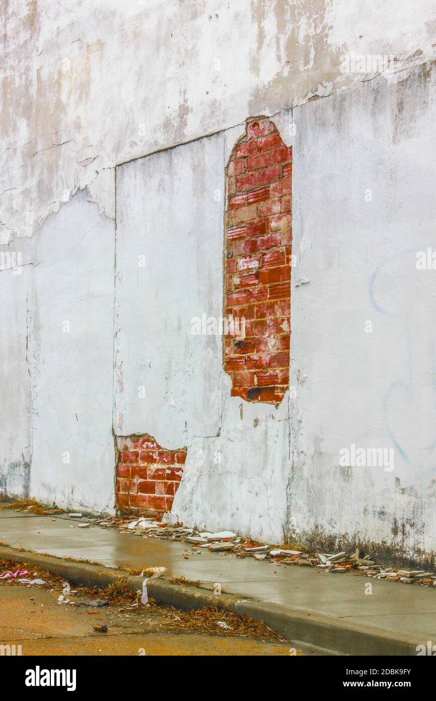 Muro sminuzzante in giornata piovosa - gesso che si staglia fuori esterno  muro di costruzione e posa in pile su marciapiede umido grugoso sotto -  stranamente bello Foto stock - Alamy