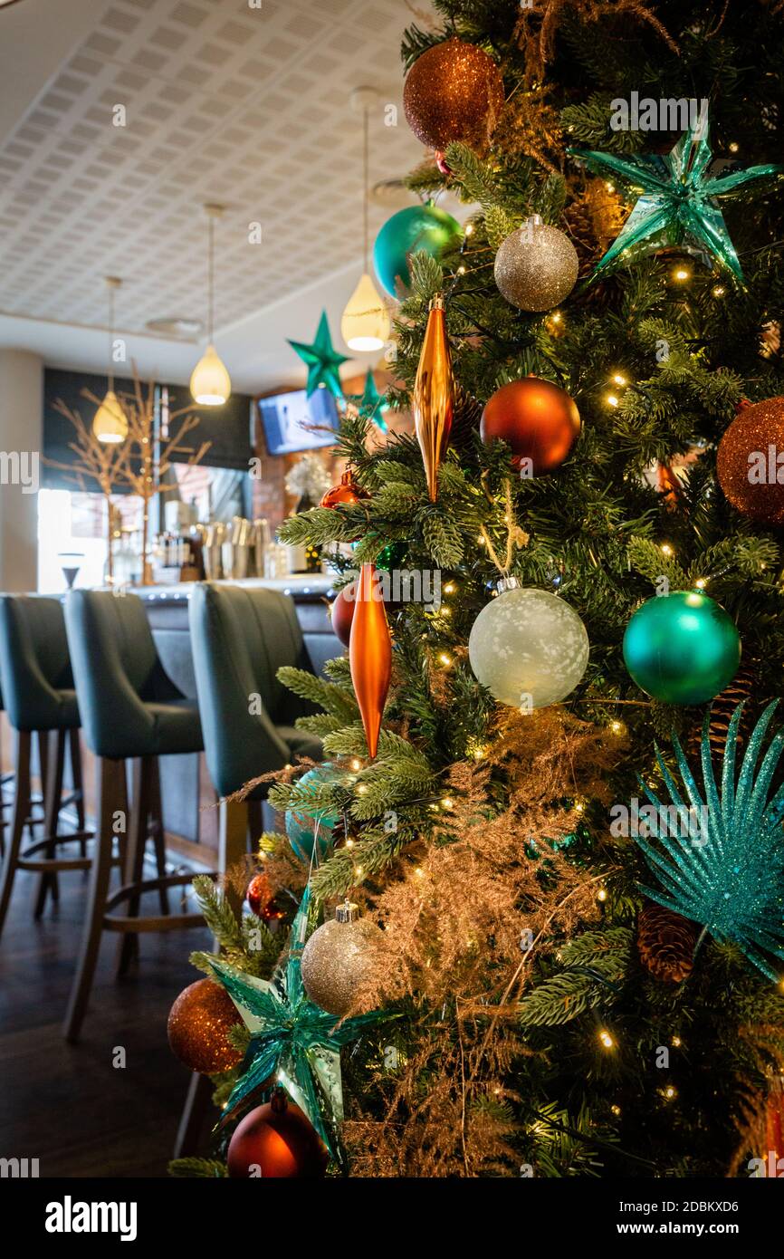 Un albero di Natale che aggiunge colore e gioia ad un'area bar. Foto Stock