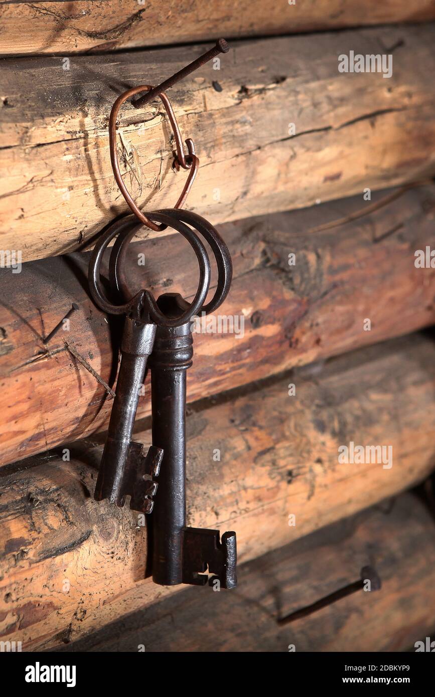 Due grandi chiavi di metallo antiche appendono sul muro di legno. Foto macro all'interno. Spazio di copia. Foto Stock