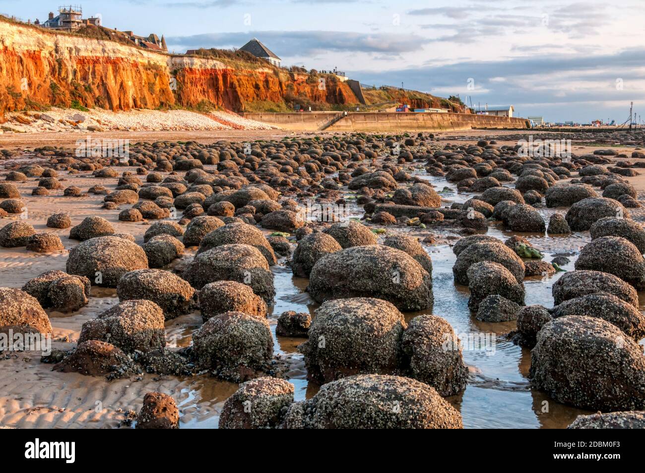 Resti di una piattaforma tagliata a onda di fronte alle famose scogliere a strisce rosse e bianche nella città costiera orientale di Hunstanton a Norfolk. Foto Stock