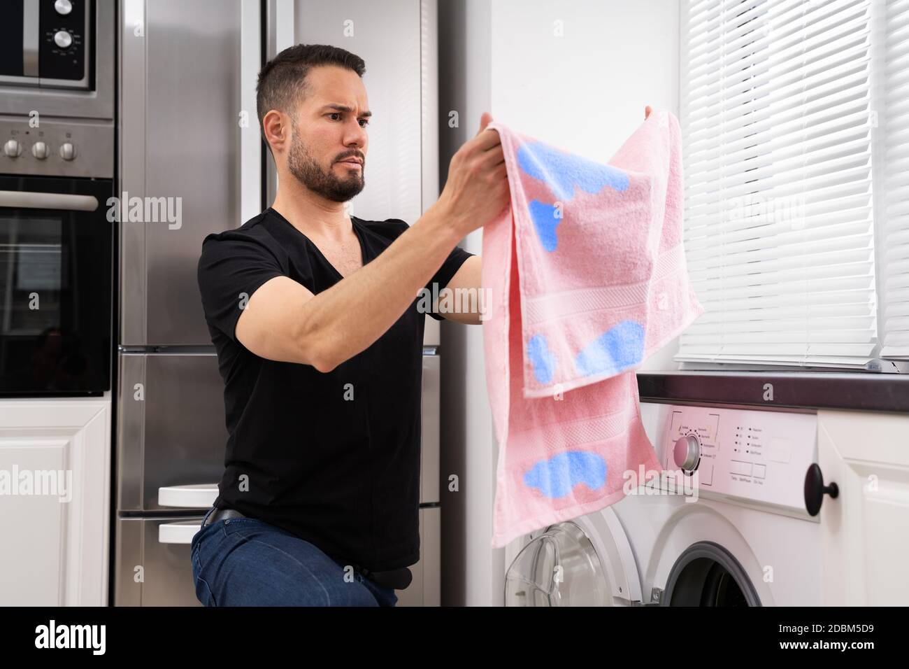 Uomo che fa lavanderia. Macchie sugli abiti dopo la lavatrice Foto stock -  Alamy