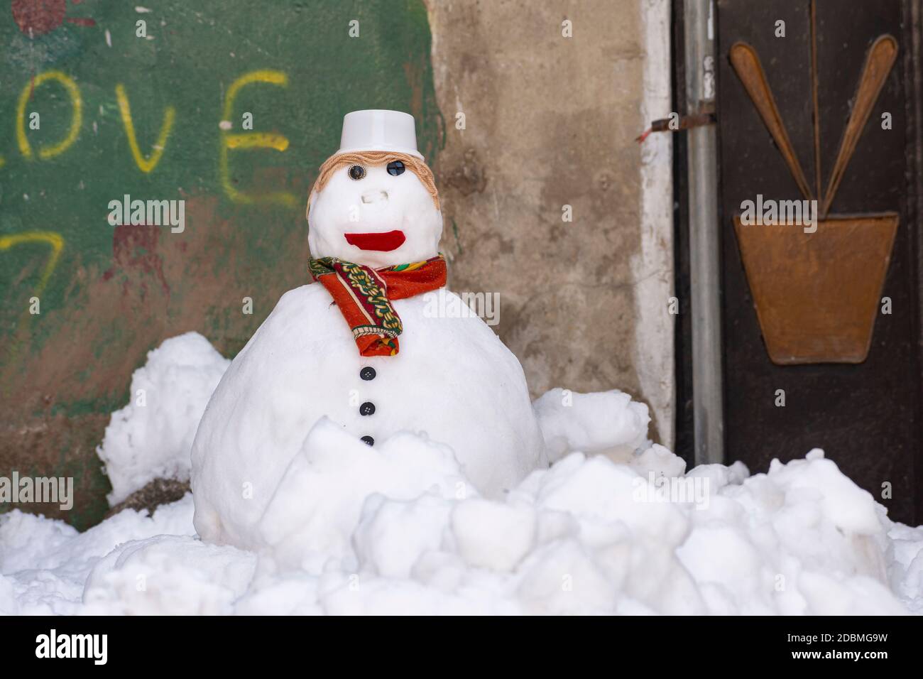 Snowman con sciarpa e cappello stand alone in vicolo Foto Stock