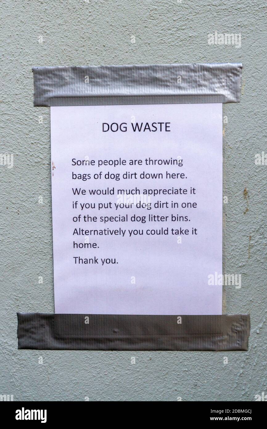 Avviso molto britannico gentile chiedendo ai camminatori del cane di smaltire con attenzione i loro cani waster, Nayland, Suffolk, Regno Unito. IMPT: Numeri di telefono rimossi in photosho Foto Stock