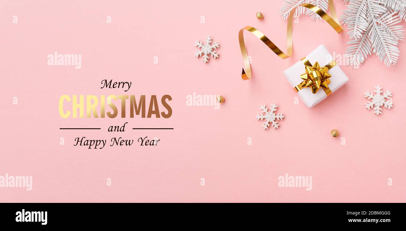 Decorazioni in oro natalizio su sfondo rosa pastello, posa piatta, spazio copia Foto Stock