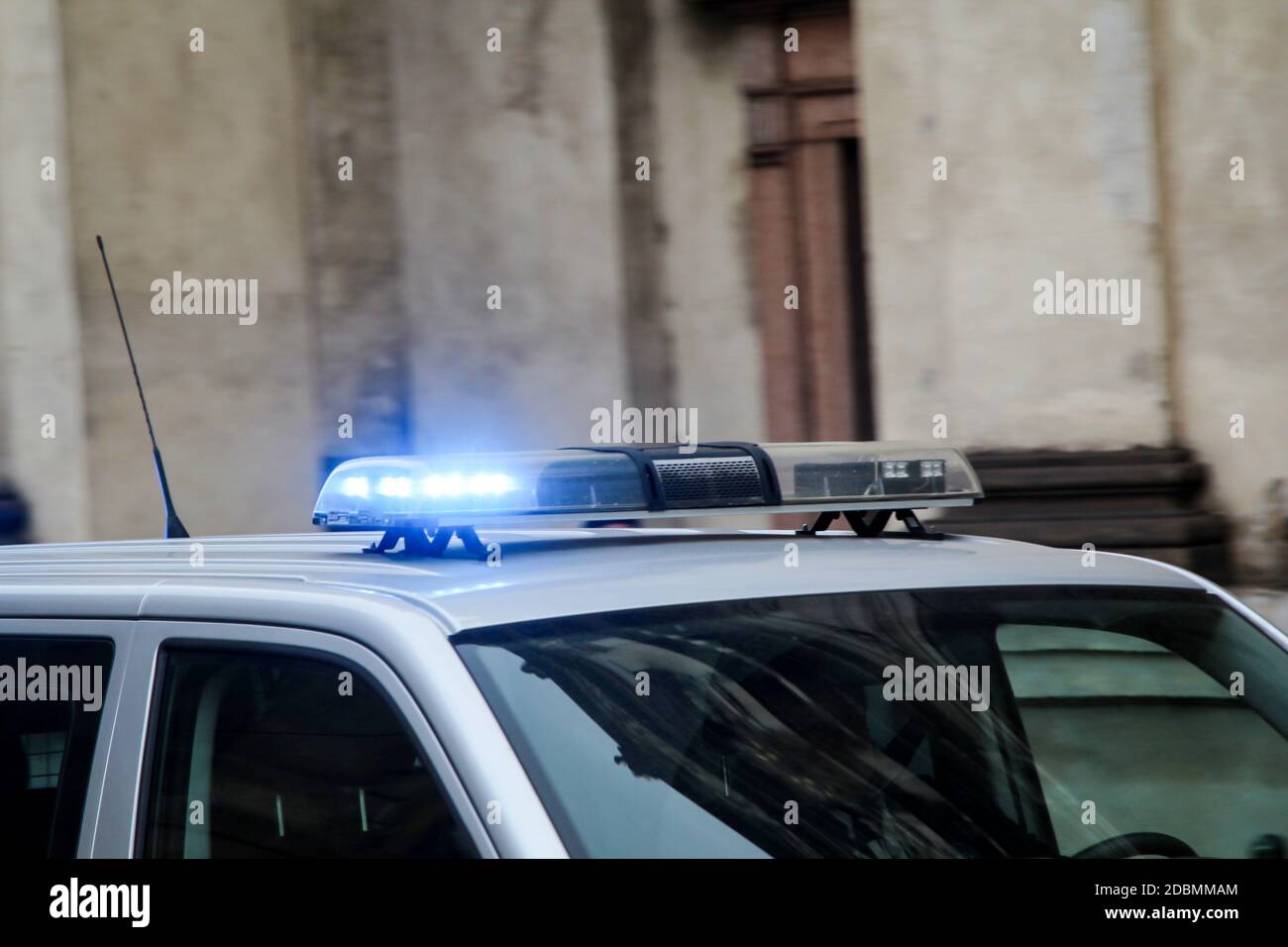 Una macchina di polizia con luci lampeggianti passa rapidamente. Foto Stock