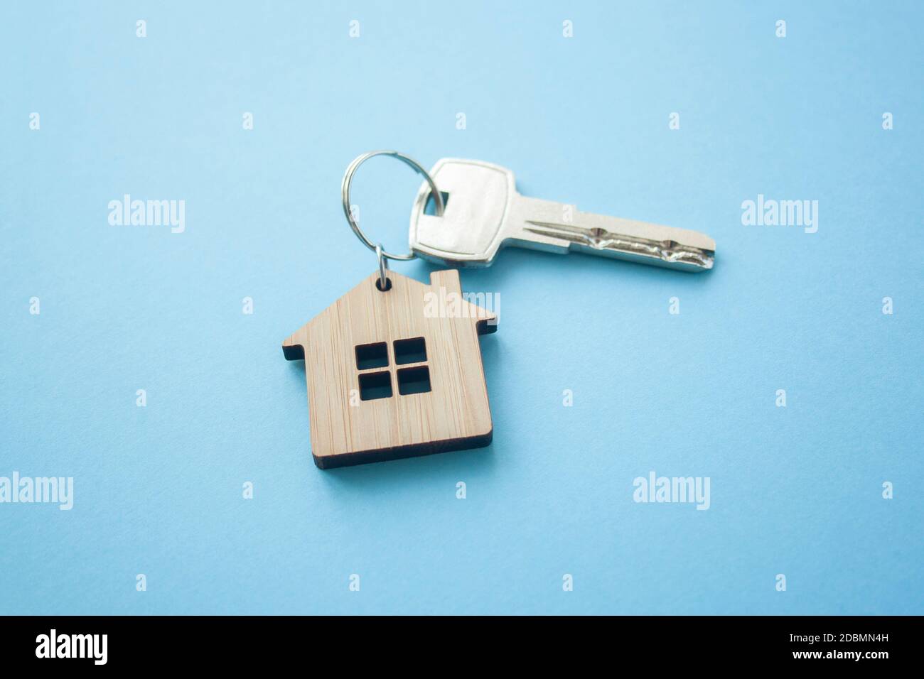 Disposizione portachiavi a forma di chiave e di casa su sfondo blu. Vista dall'alto, disposizione piatta. Immobiliare, concetto di assicurazione, ipoteca, comprare vendere casa, realtor co Foto Stock