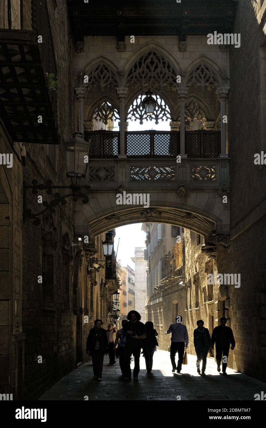 Persone che camminano sotto El Pont del Bistro (Ponte del Vescovo) nel quartiere Gotico di Barcellona, Catalogna, Spagna Foto Stock