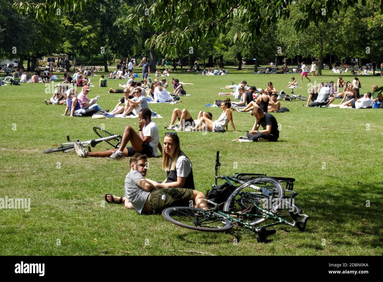 I giovani si godono una giornata di sole a Victoria Park, Londra Inghilterra Regno Unito Foto Stock