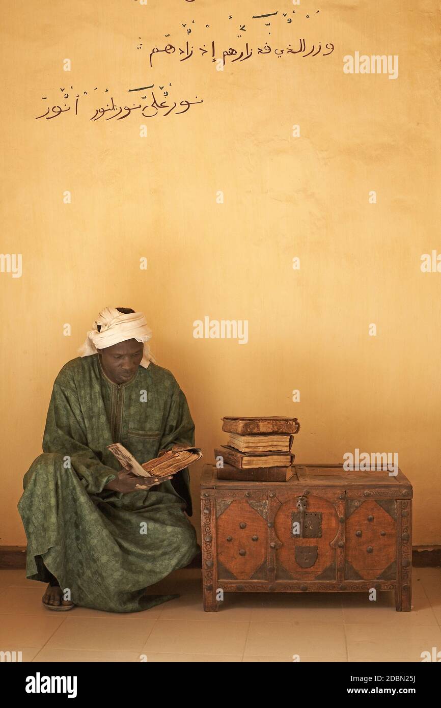 Uomo con manoscritti presso la Biblioteca privata al-Wangari, a Timbuktu , Mali , Africa . Foto Stock