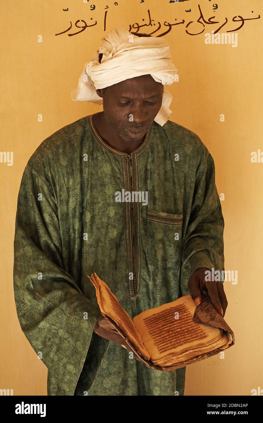 Uomo con manoscritti presso la Biblioteca privata al-Wangari, a Timbuktu , Mali , Africa . Foto Stock
