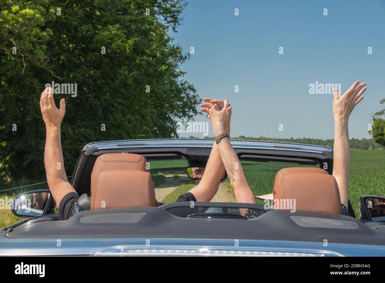 Due persone anziane con una lussuosa auto convertibili Foto Stock