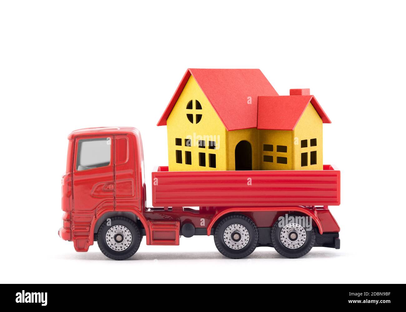 Rosso camion miniatura con casa su sfondo bianco Foto Stock
