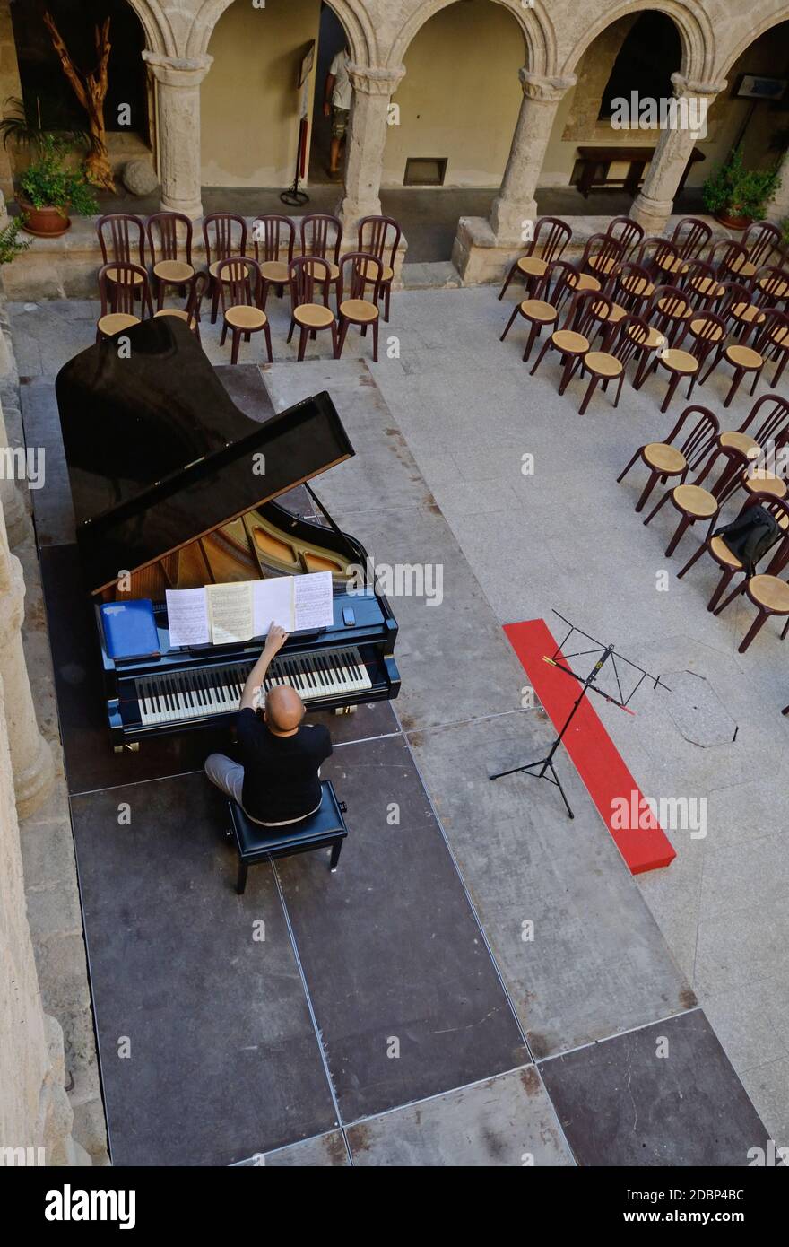 pianista suona un pianoforte all'interno del chiostro del Antica chiesa di San Francesco ad Alghero Foto Stock