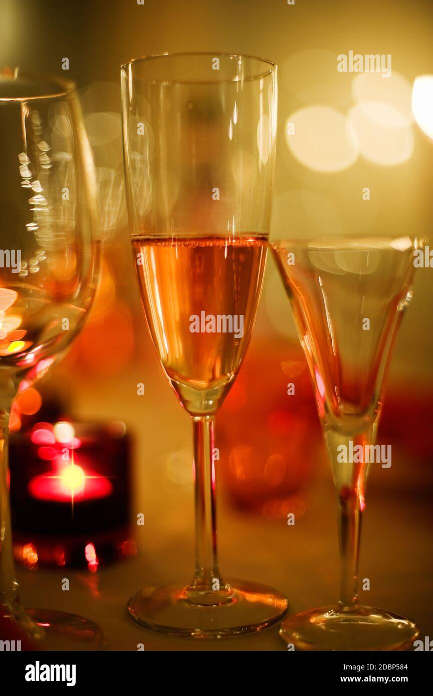 Champagne per le vacanze, luci a lume di candela e sensazione di festa, sfondo bokeh sfocato. Foto Stock