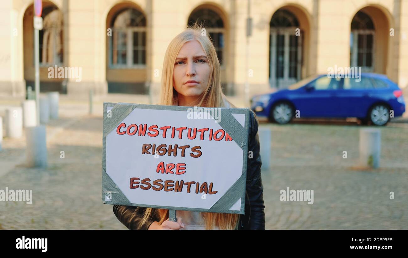 Protesta a piedi: Donna che sostiene la tutela dei diritti costituzionali. Tiene la bandiera e va sulla strada. Foto Stock