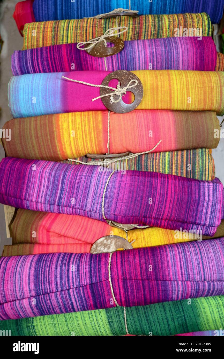 Batik panno in tessuto per la vendita arrotolato in su nel mercato. Arte e cultura balinese. Primo piano di sarong colorato arrotolato. Rotoli di tessuto colorati. Tradizionale indù Foto Stock