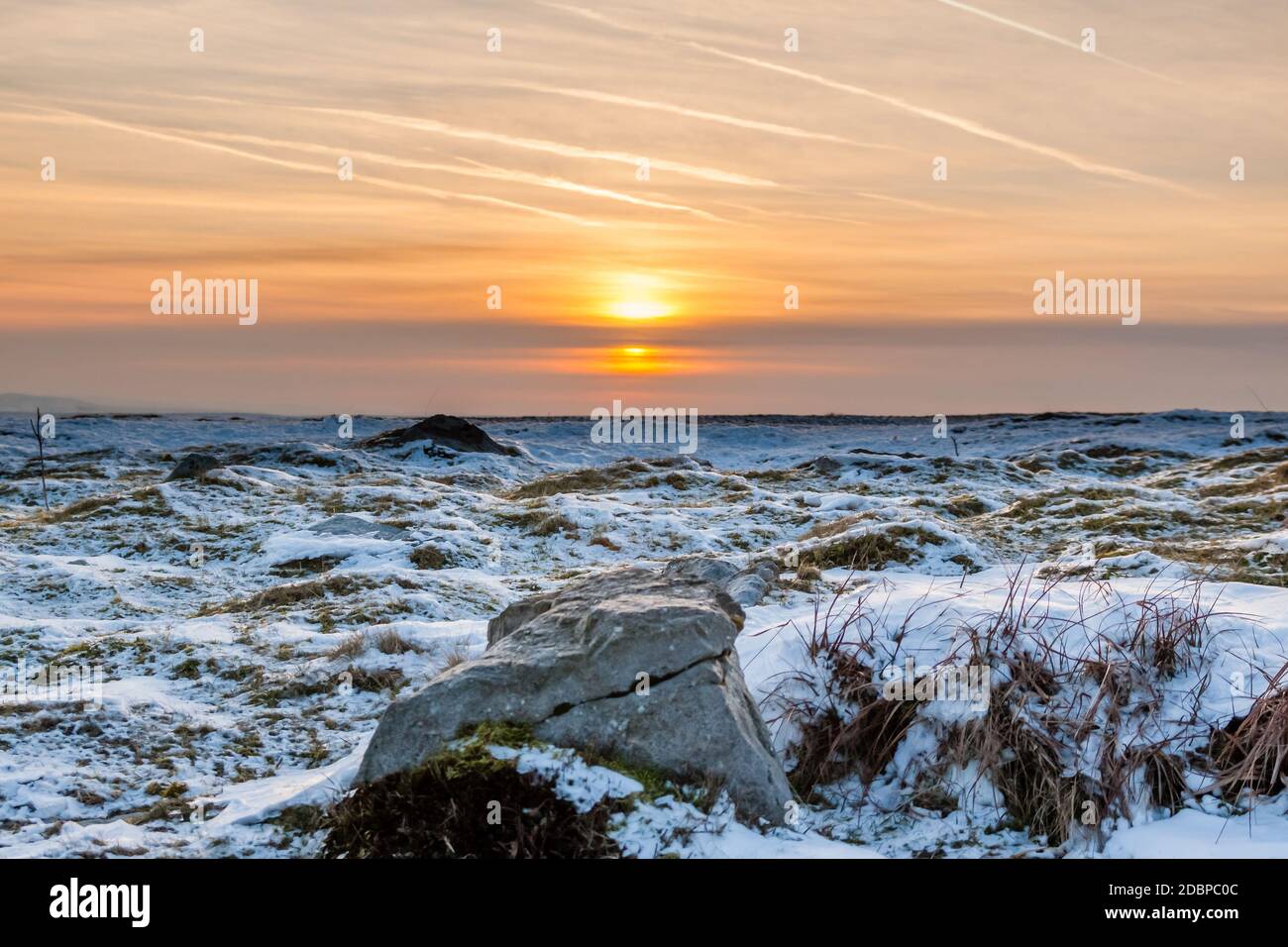 Tramonto su un freddo e ghiacciato paesaggio invernale in alta brughiera Foto Stock