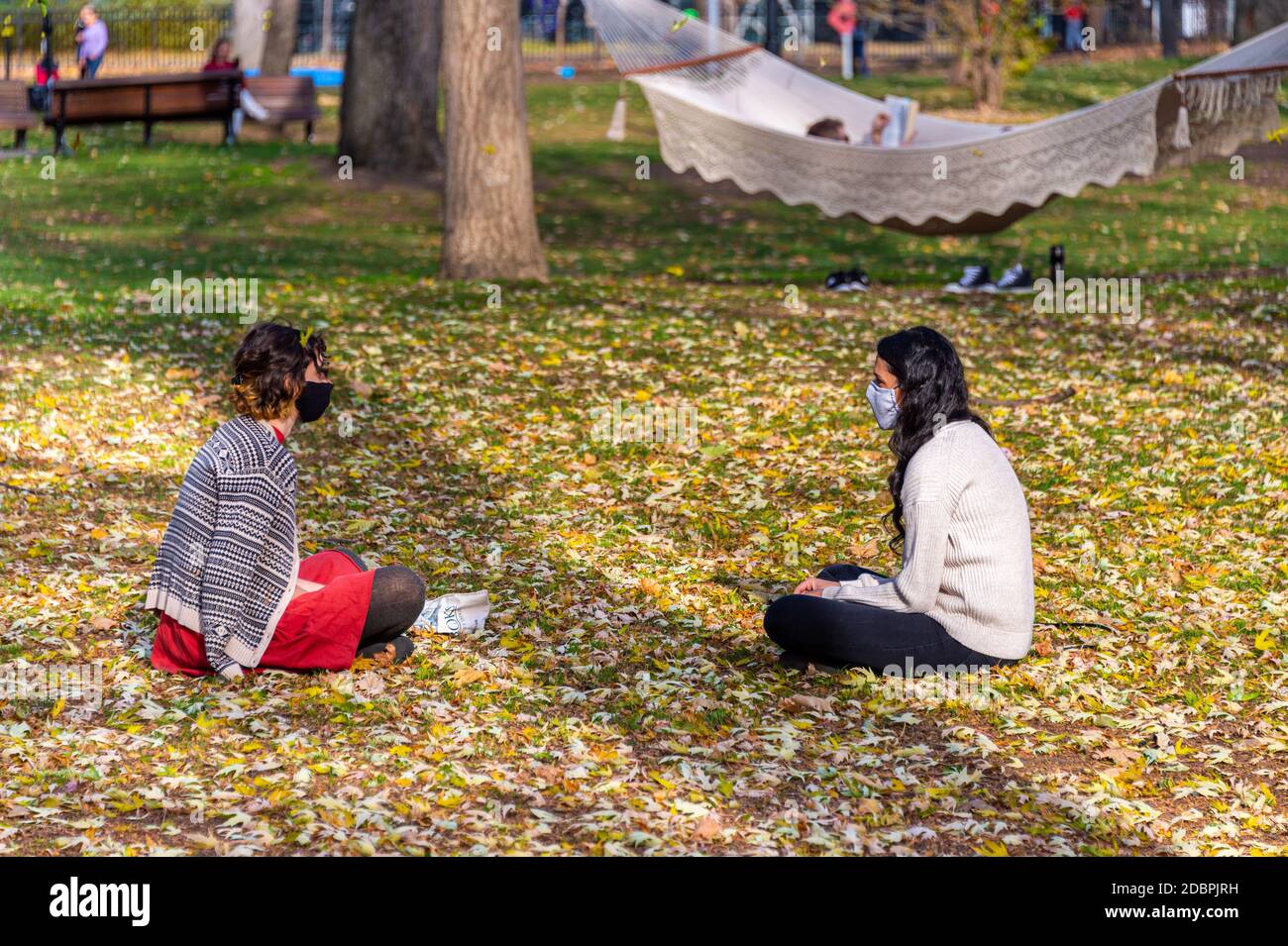 Montreal, CA - 7 novembre 2020: Due amici che praticano la distanza fisica in un parco Foto Stock