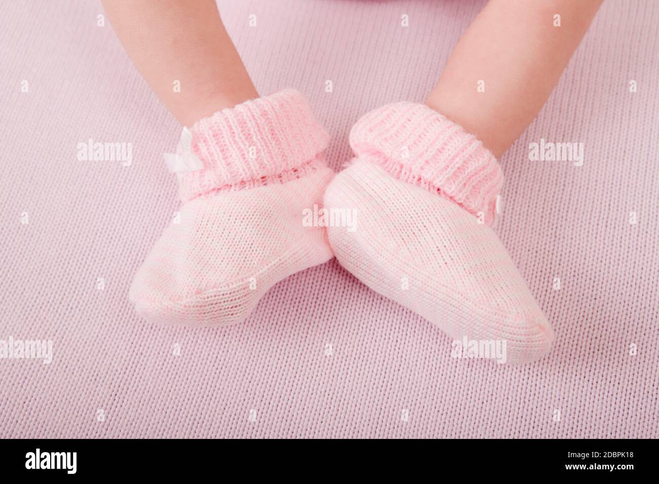 I piedi del neonato si avvicinano. Piedini del bambino in calze bianche di  spugna, bambino che si trova sul letto Foto stock - Alamy