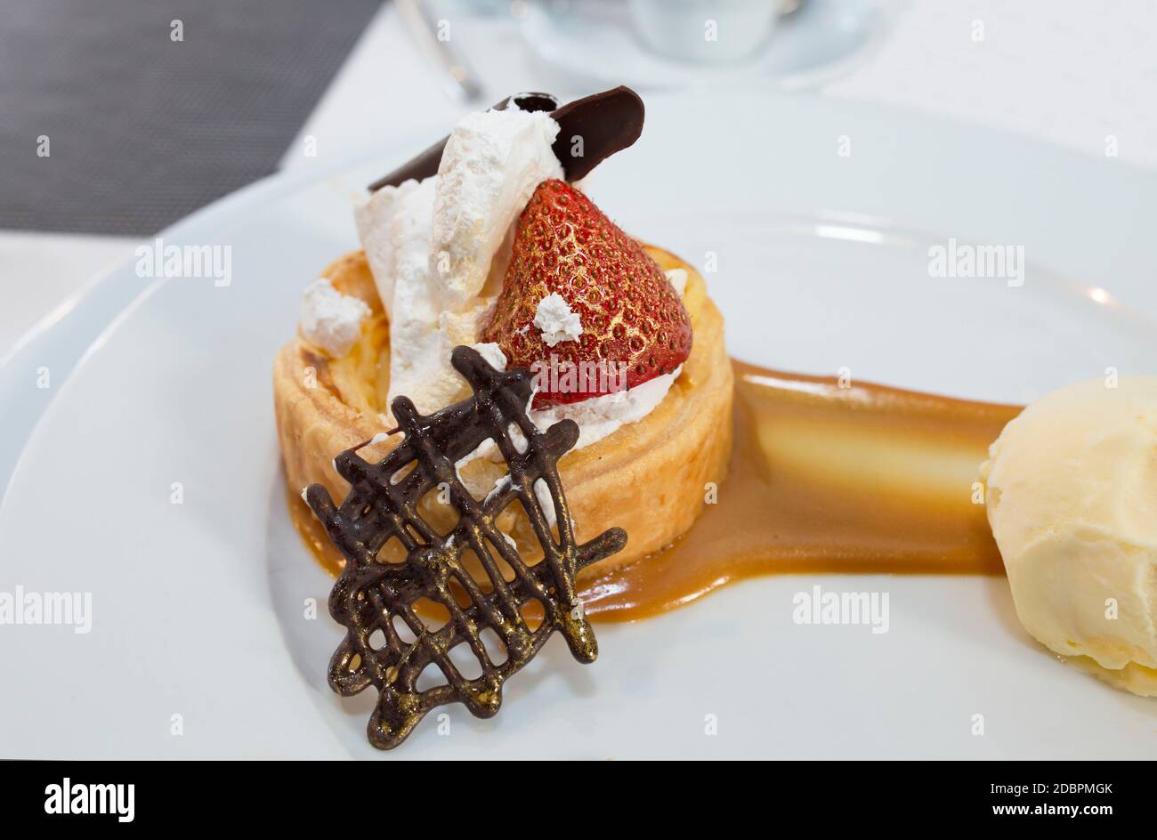 Dessert di alta cucina rivestito di polvere d'oro commestibile. Sfoglia ripiena di creme brulee, lampone e mattonelle di cioccolato con vaniglia Madagascar Foto Stock