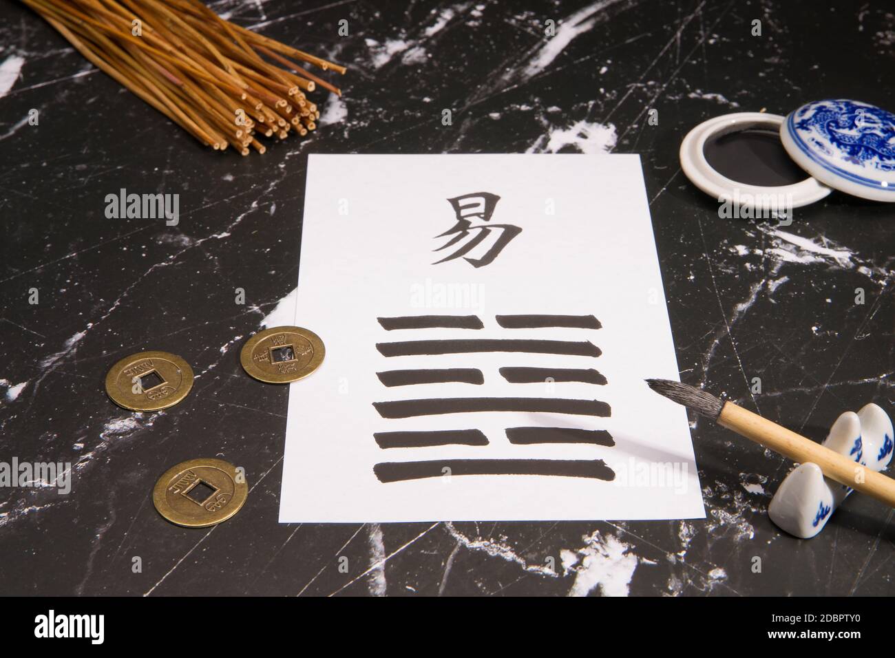 Primo piano di un accordo di i Ching con il 63esimo esagramma (dopo la complicazione / Chi Chi) scritto con un pennello di inchiostro cinese su carta di riso. Ci sono anche Foto Stock