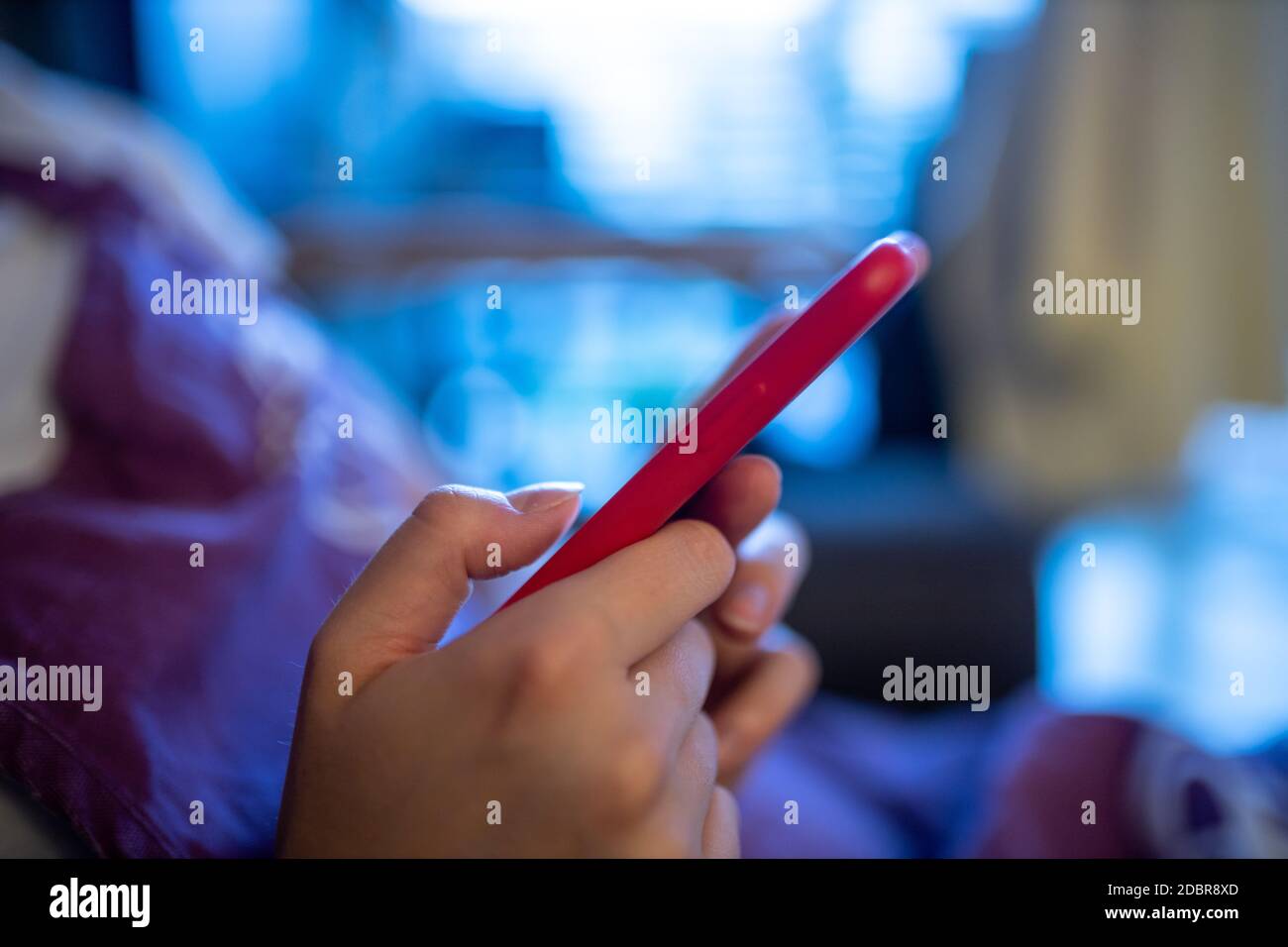 donna che lavora al telefono in una custodia in silicone rossa. Messa a fuoco selettiva Foto Stock