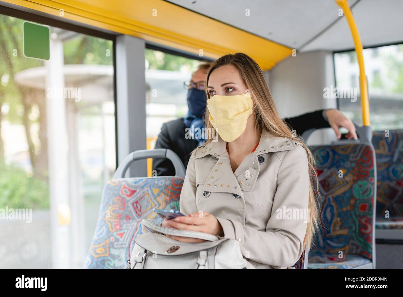Persone che indossano maschere in autobus utilizzando i mezzi pubblici di custodia distanza corretta Foto Stock