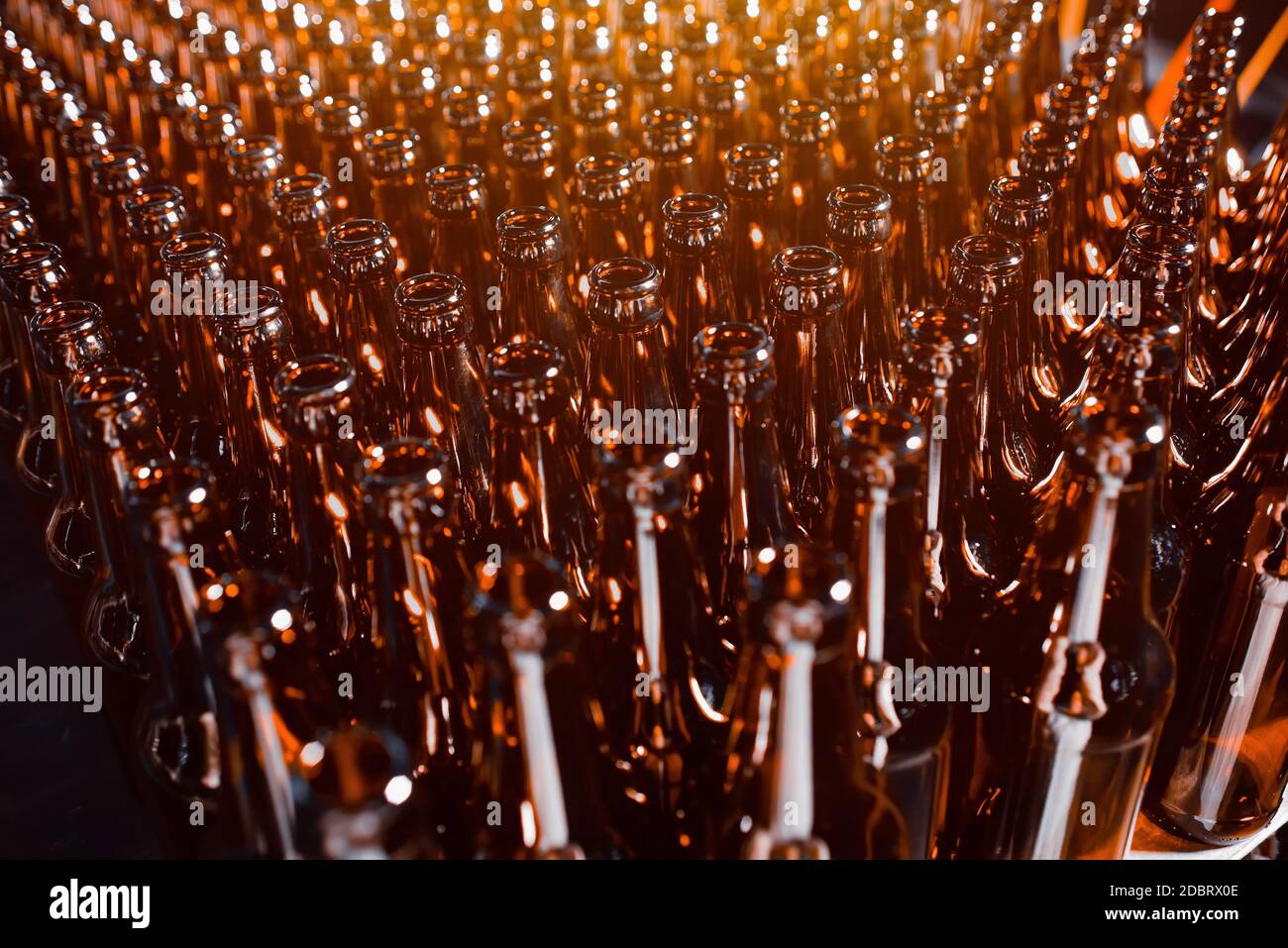 File di bottiglie di birra di vetro di colore marrone primo piano Foto Stock