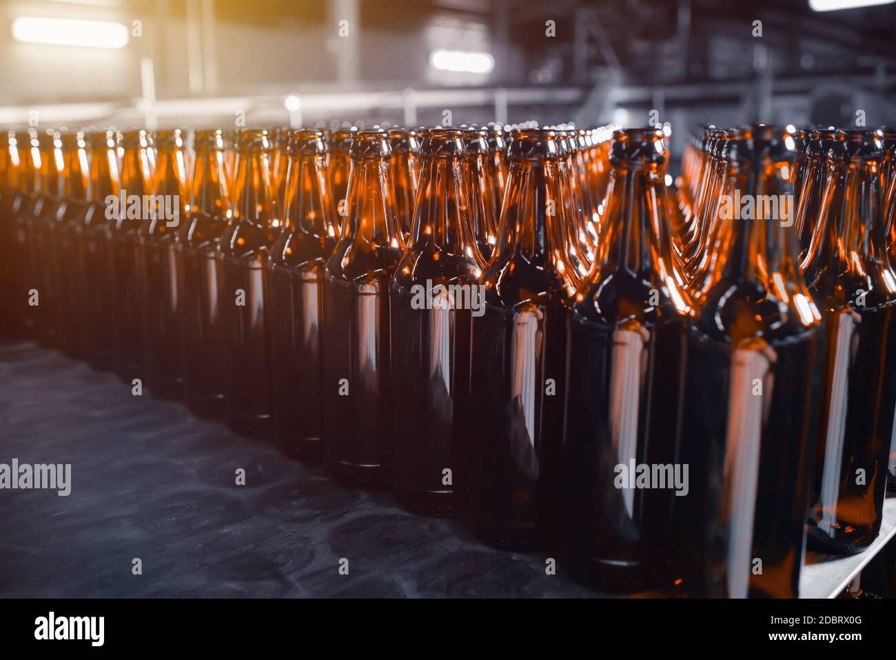 Ranghi di bottiglie di birra di vetro di colore marrone primo piano sulla pila Foto Stock