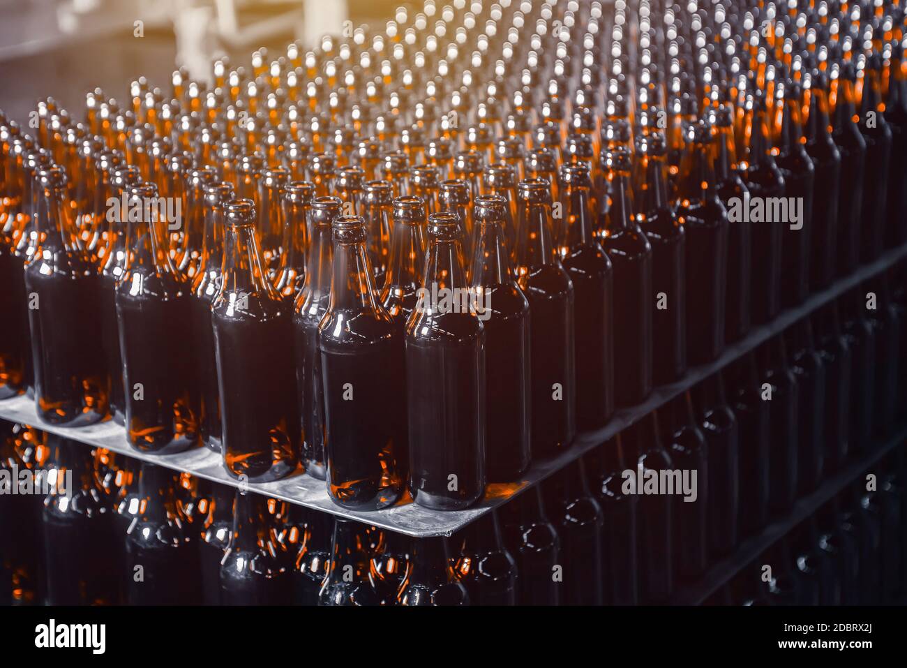 File di bottiglie di birra di vetro marrone sulla pila Foto Stock