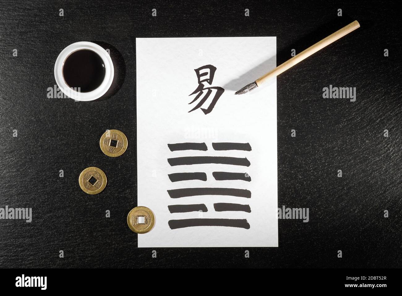 Primo piano di un accordo di i Ching su ardesia con il 63esimo esagramma (dopo la complicazione / Chi Chi) scritto con un pennello cinese inchiostro su carta di riso. Lì Foto Stock