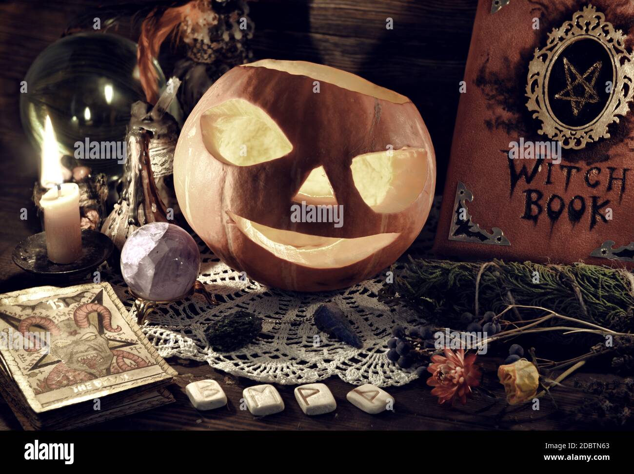 Halloween ancora vita con libro di strega, Jack o Lanterna zucca, tarocchi carta e rune. Storia esoterica, wicca e occulta, narrazione di fortuna e divinat Foto Stock