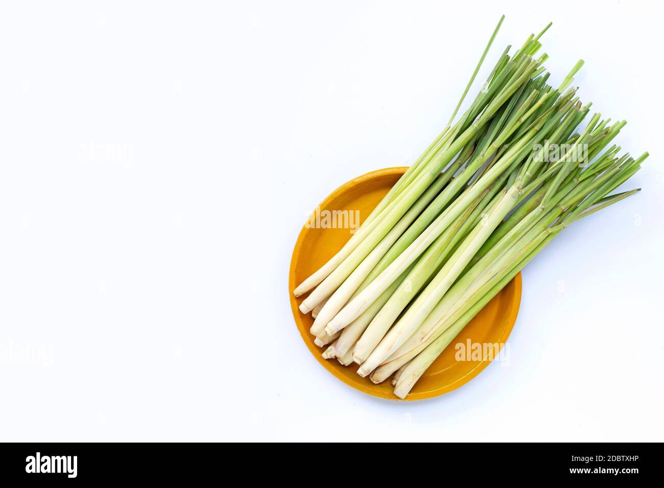 Citronella fresca su piatto giallo su fondo bianco. Spazio di copia Foto Stock Citronella fresca su piatto giallo su fondo bianco. Spazio di copia Foto Stock