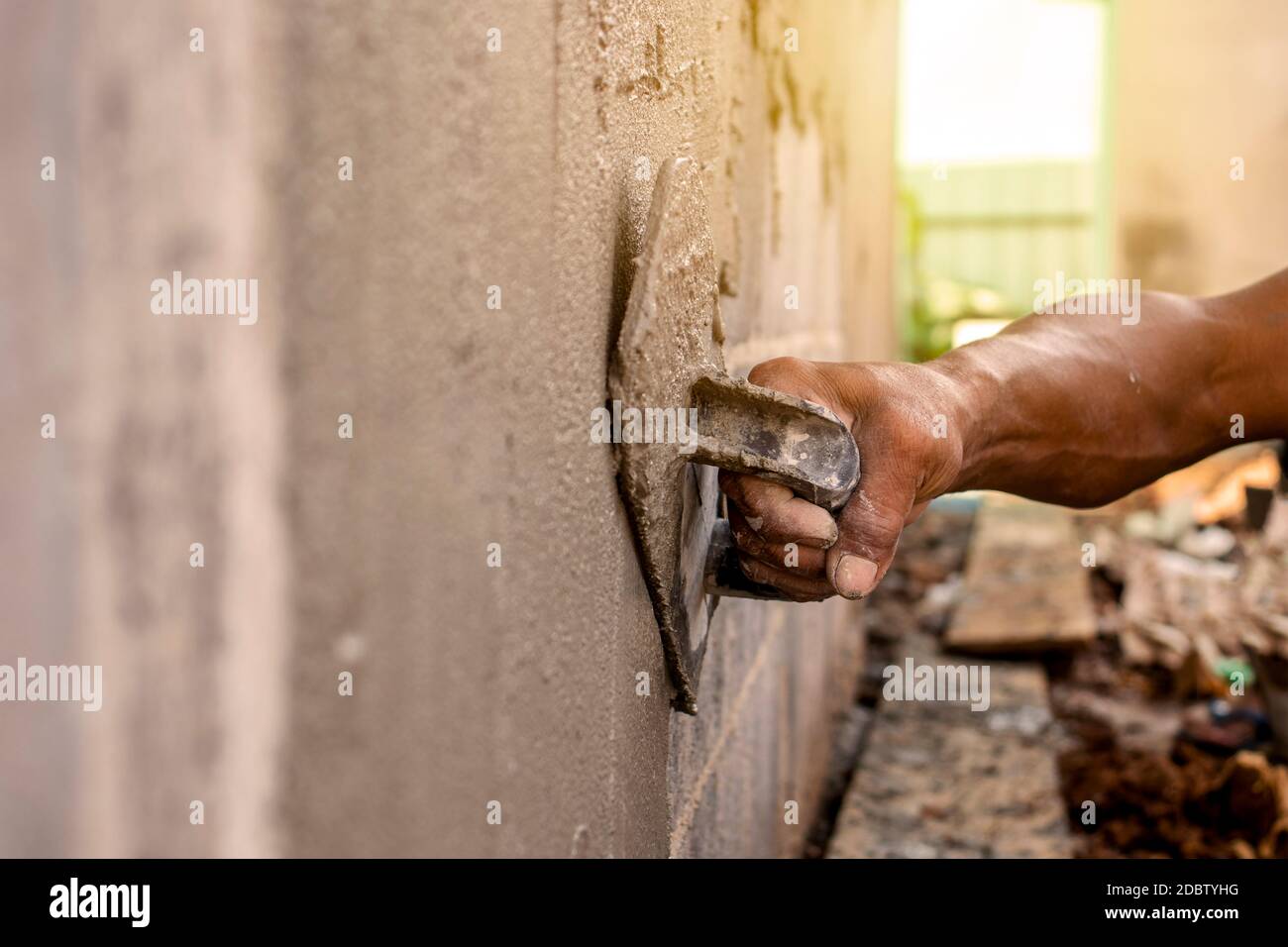 Primo piano di lavoratori che utilizzano cazzuola di gesso per intonacare le pareti per la costruzione di case, idee di lavoro, e la costruzione residenziale. Foto Stock