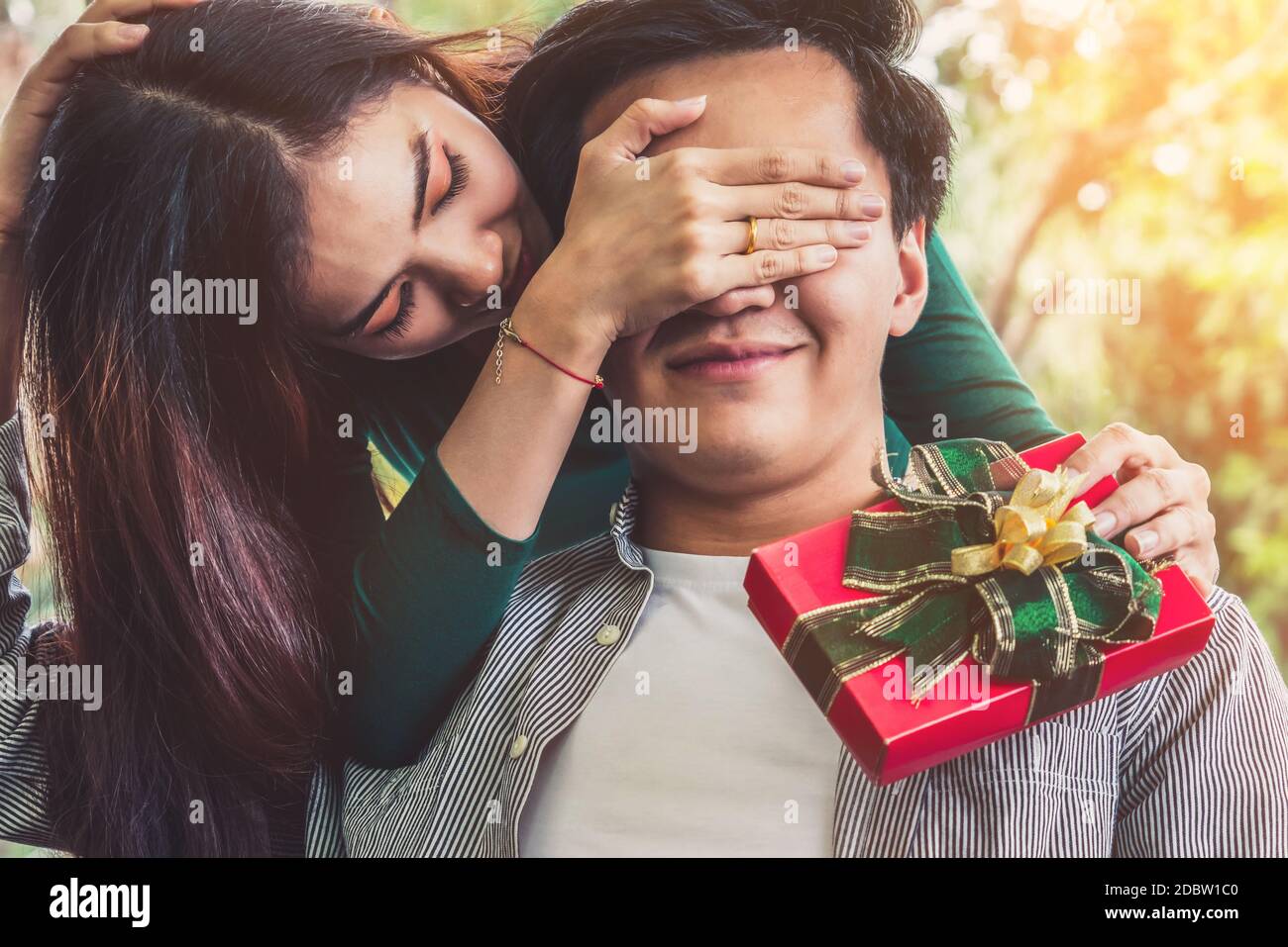 Coppia felice che dà regalo per celebrare l'anniversario. Stile di vita matrimoniale, amore e concetto di relazione. Foto Stock