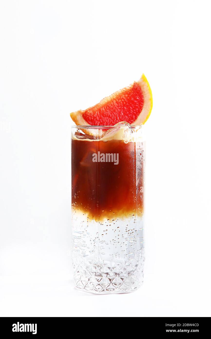 Bevanda analcolica a base di caffè e acqua minerale. Un pezzo di pompelmo sulla parte superiore. Una bevanda dissetante. Foto verticale. Spazio di copia. Foto Stock