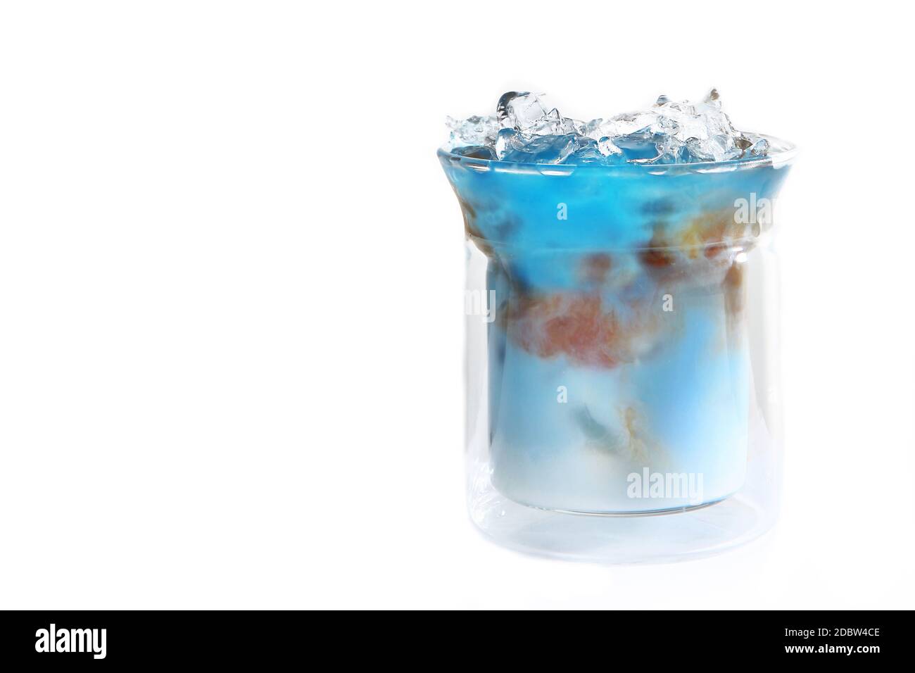 Tè blu matcha con latte e caffè in una tazza di vetro. Bevanda analcolica. Sfondo chiaro. Spazio di copia. Foto Stock