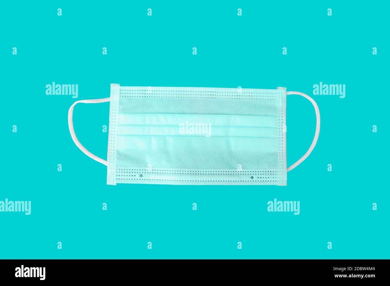 Maschera per protezione da virus e chirurgia, con un cinturino in gomma su sfondo blu con il tracciato di ritaglio. Concetti antibatterici e antivirus Foto Stock