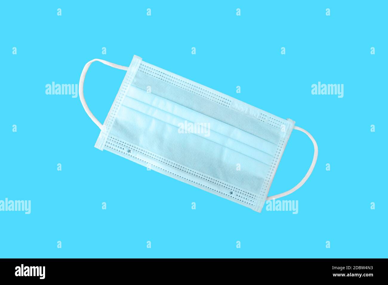 Maschera per protezione da virus e chirurgia, con un cinturino in gomma su sfondo blu con il tracciato di ritaglio. Concetti antibatterici e antivirus Foto Stock