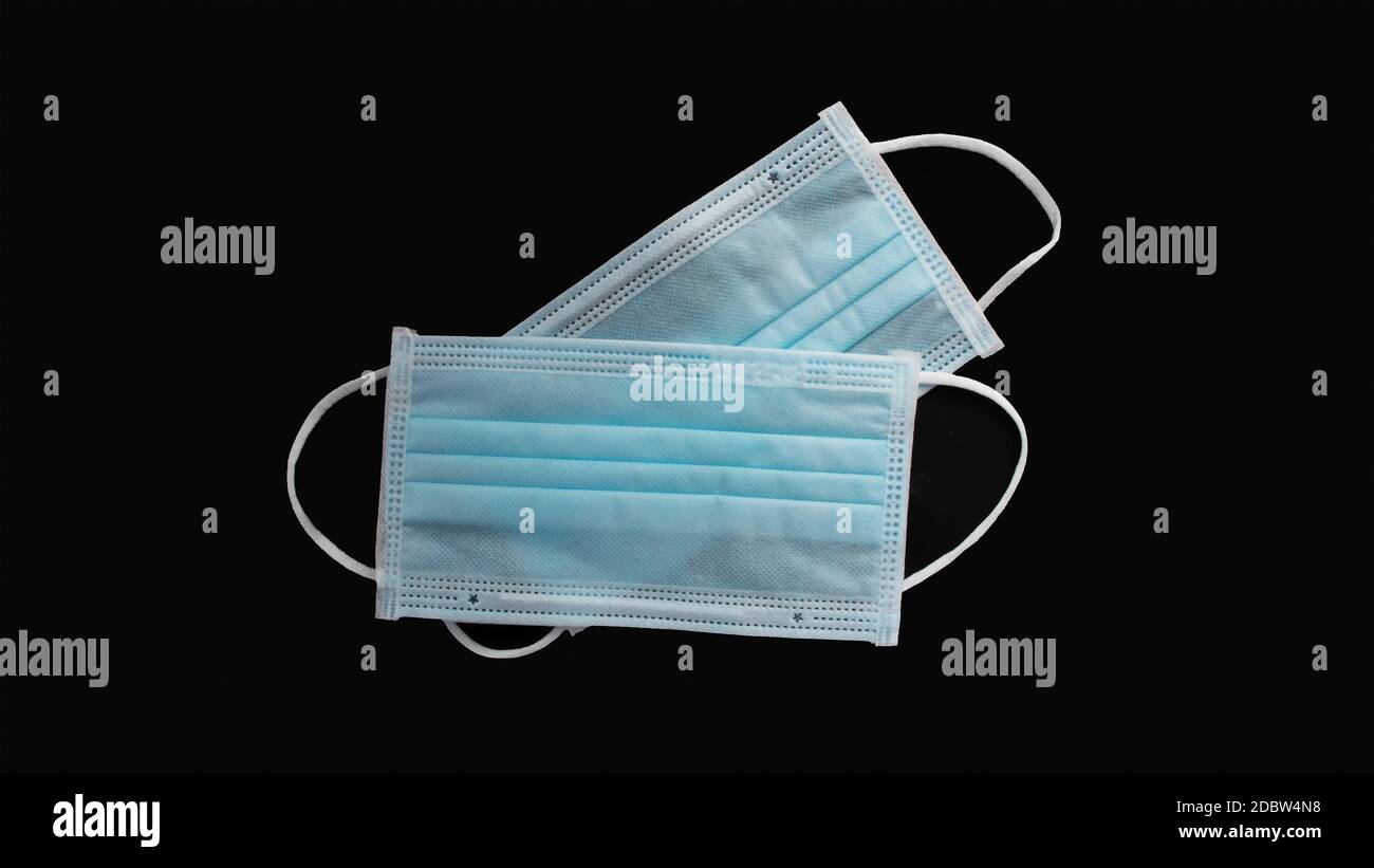 Maschera per protezione da virus e chirurgia, con un cinturino in gomma su sfondo nero con il percorso di ritaglio. L'idea di ​​antibacterial e anti-virus. Foto Stock