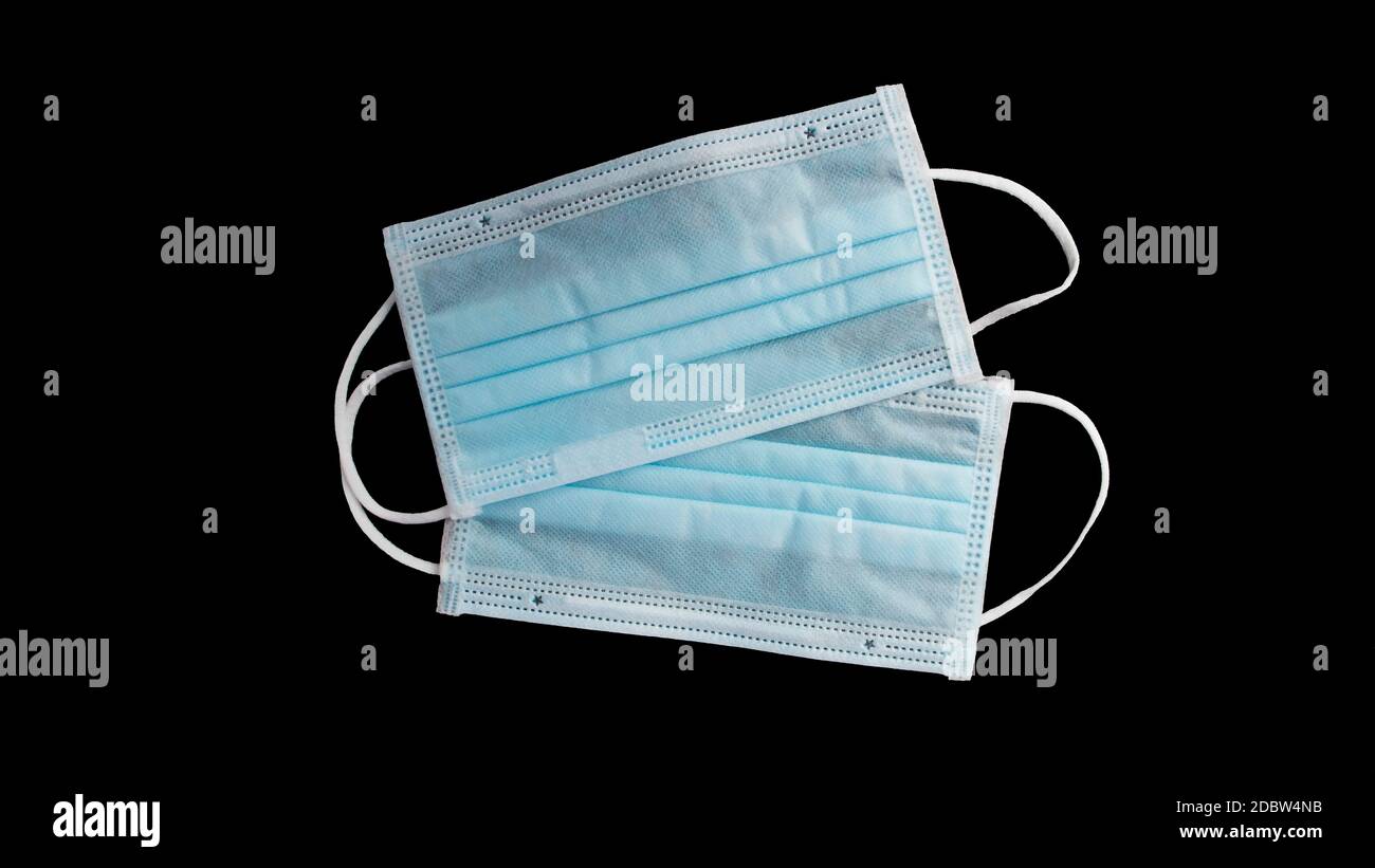 Maschera per protezione da virus e chirurgia, con un cinturino in gomma su sfondo nero con il percorso di ritaglio. L'idea di ​​antibacterial e anti-virus. Foto Stock