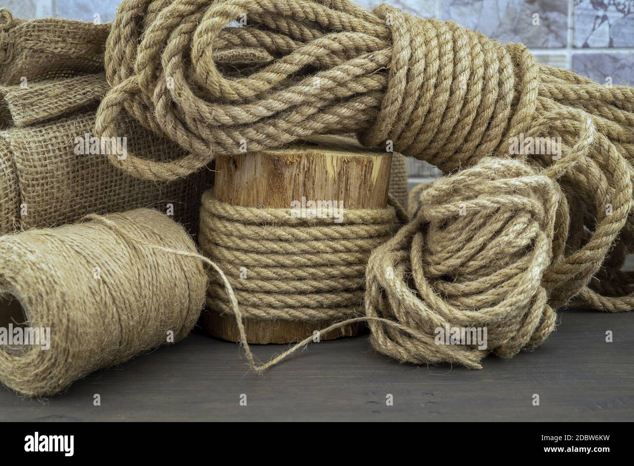 Corda di iuta e rocchetti di fili di tela o di iuta di spago nel vicino sul  rustico sfondo di legno Foto stock - Alamy