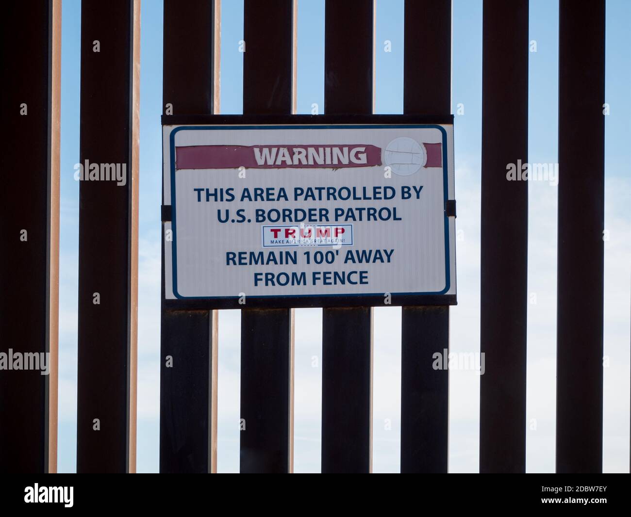 Cartello di avvertenza sul muro di confine tra Stati Uniti e Messico con Decalcomania Trump Foto Stock