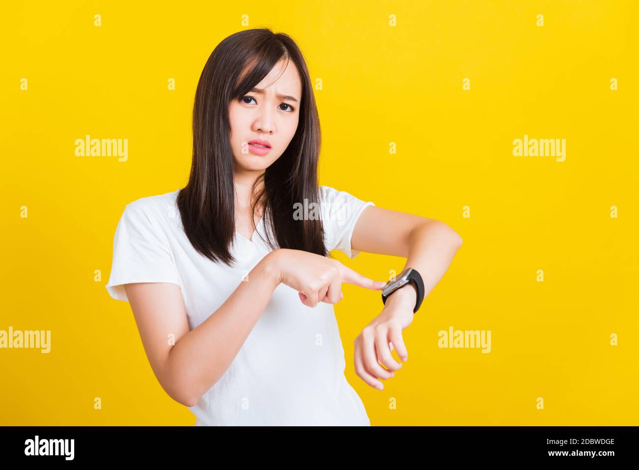 Siete in ritardo non in tempo, Ritratto asiatico di una bella donna felice giovane paura ragazza casual mostrando e puntando dito il suo studio orologio da polso è stato girato Foto Stock
