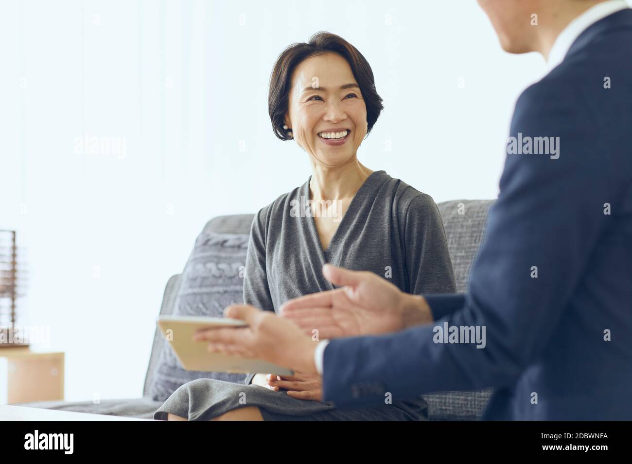Donna giapponese di mezza età sorridente nella stanza Foto Stock